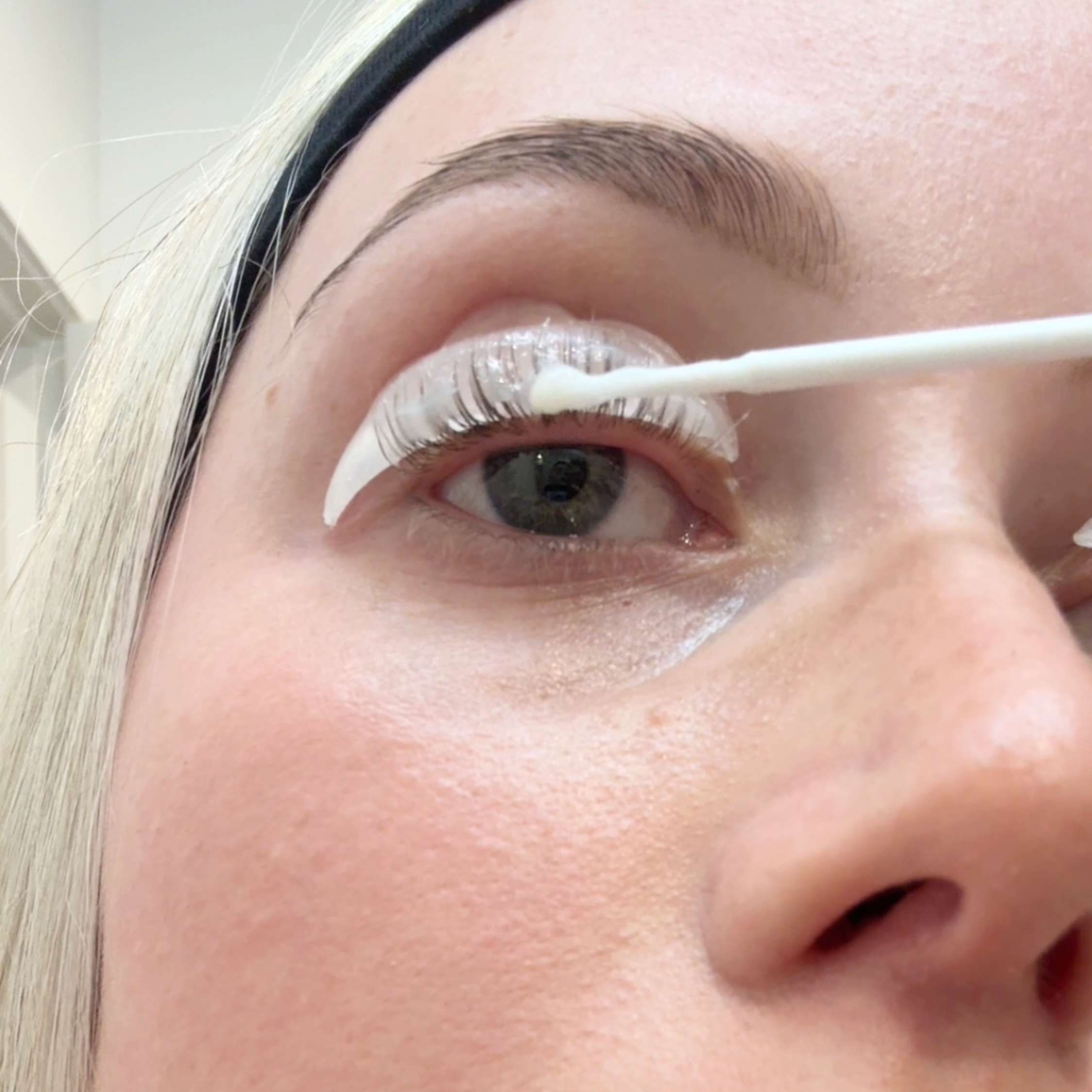 Applying lifting lotion on eyelashes for a lash lift at home 