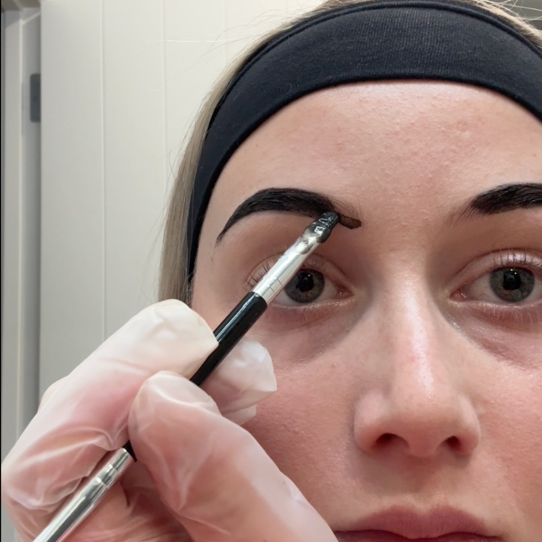 Person applying tint to eyebrows at home