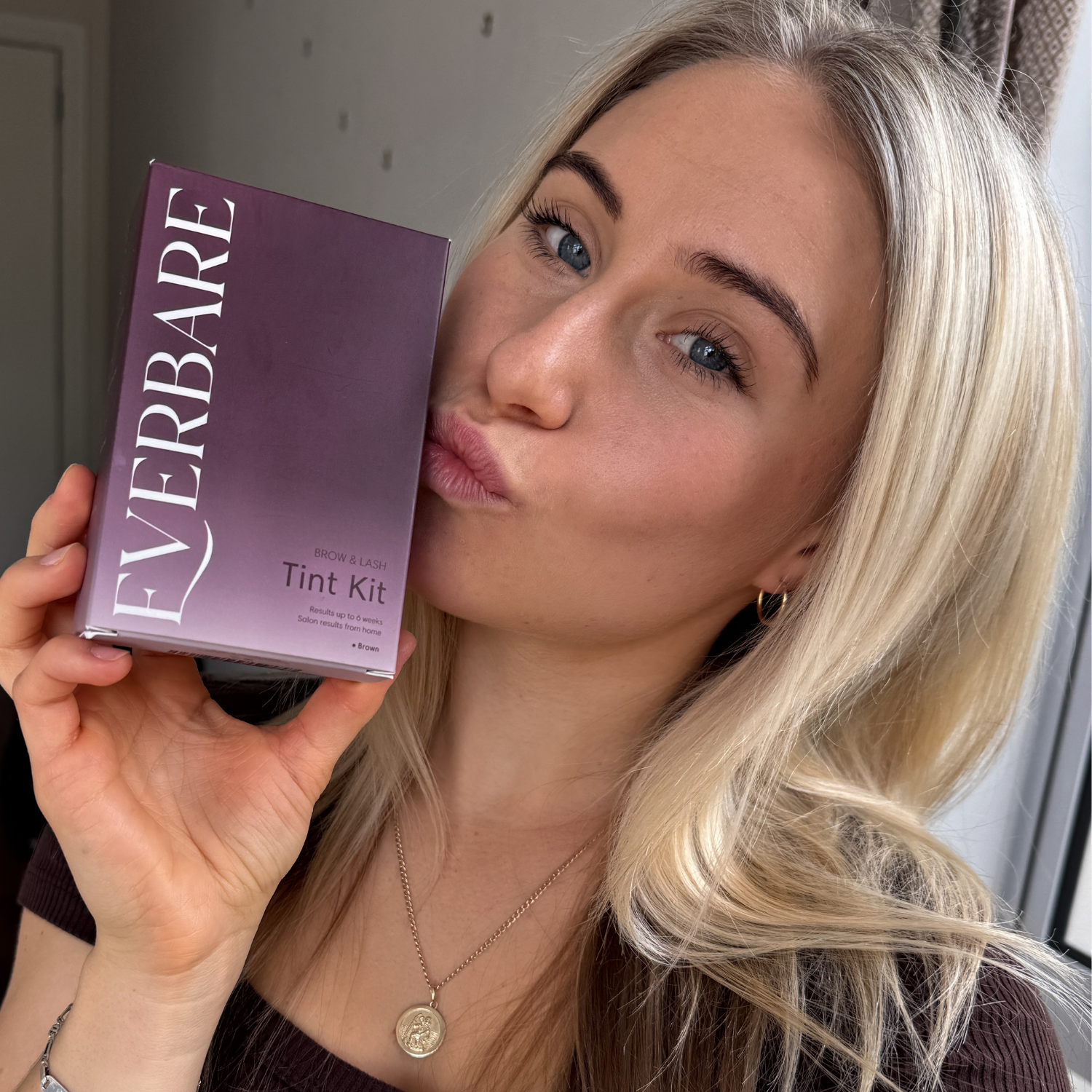 Girl holding everbare tint kit for eyelashes and brows at home use